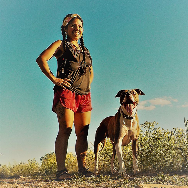 Runner and community activist Leticia Romero poses outside with her dog